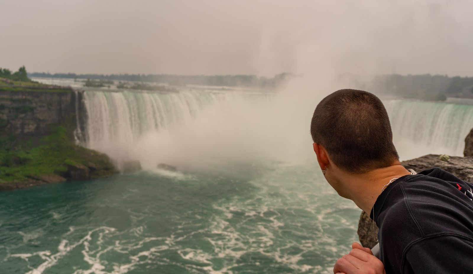 A visitor leans out over the brink of the falls