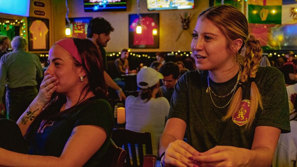 Two people talking in a crowded bar
